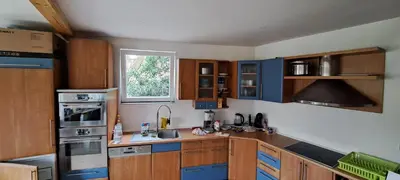 a kitchen with wooden cabinets and blue appliances at BohniceDrahanVltavaRelax in Zdiby