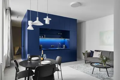a dining room with a table and a blue wall at Grace Apartment by Prague Castle in Prague