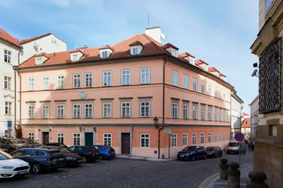 a large building with cars parked in a parking lot at Grace Apartment by Prague Castle in Prague