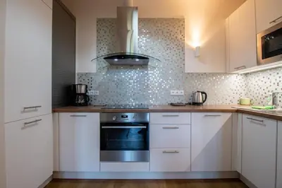 a kitchen with white cabinets and a stove at Stay Inn Apartments Ve smeckah in Prague