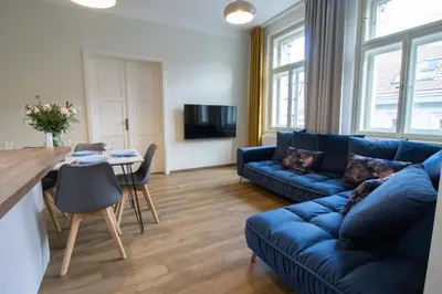 a living room with a blue couch and a table at Stay Inn Apartments Ve smeckah in Prague