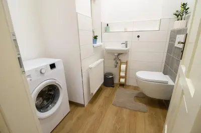 a small bathroom with a washing machine and a toilet at Stay Inn Apartments Ve smeckah in Prague