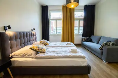 a bedroom with a bed and a couch at Stay Inn Apartments Ve smeckah in Prague