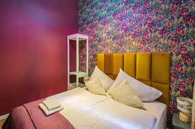 a bedroom with a large bed with a colorful wall at 4BDR Old Town flat by Church of St Anne in Prague