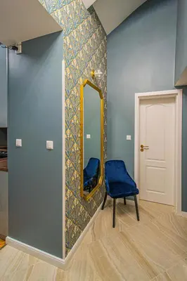 a blue chair in a room with a mirror at 4BDR Old Town flat by Church of St Anne in Prague