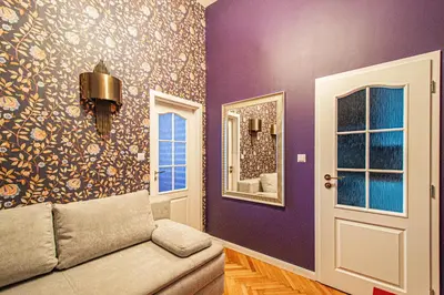 a living room with purple walls and a couch at 4BDR Old Town flat by Church of St Anne in Prague