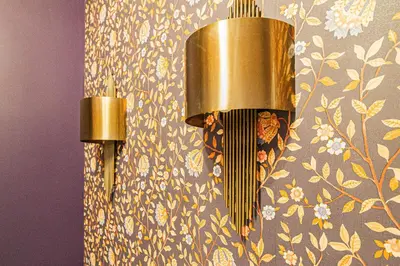 two lights on a wall with a floral wallpaper at 4BDR Old Town flat by Church of St Anne in Prague