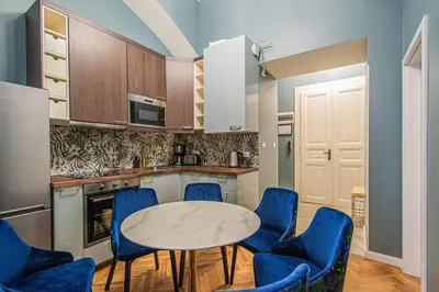 a kitchen with a table and blue chairs at 4BDR Old Town flat by Church of St Anne in Prague