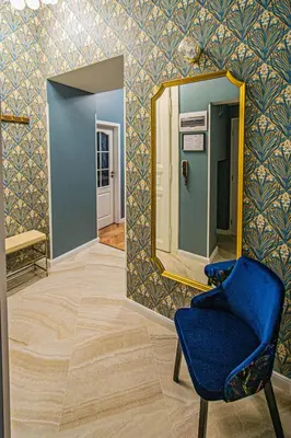 a room with a blue chair and a mirror at 4BDR Old Town flat by Church of St Anne in Prague