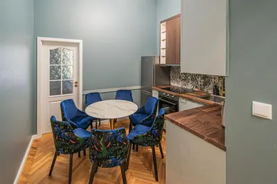 a kitchen with blue chairs and a table and a counter at 4BDR Old Town flat by Church of St Anne in Prague