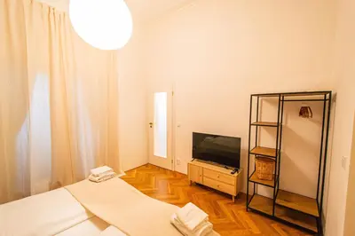 a white room with a bed and a television at 3BDR main square spacious designed apartment in Prague