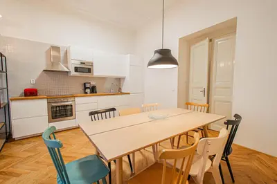 a kitchen and dining room with a wooden table and chairs at 3BDR main square spacious designed apartment in Prague