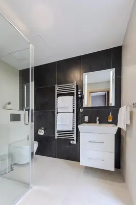 a bathroom with a sink and a tv in a room at Hotel Tříška in Brandýs nad Labem