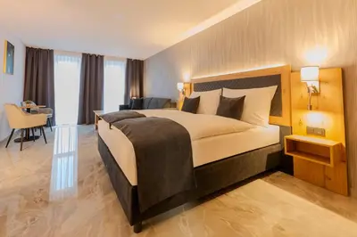 a bedroom with a bed and a desk and a chair at Hotel Tříška in Brandýs nad Labem