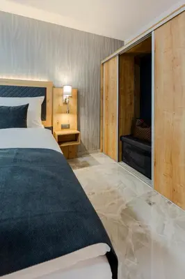 a hotel room with a couch and a bed at Hotel Tříška in Brandýs nad Labem