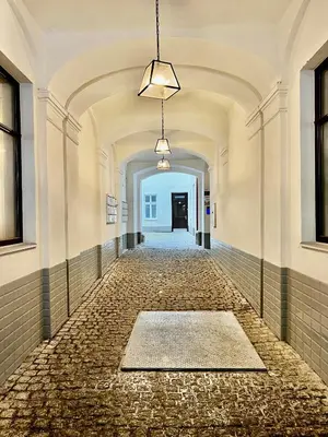 an empty hallway with a tile floor and a ceiling at DOMIRA Riverside apartment in Prague