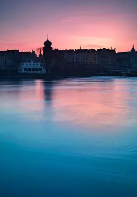 a view of a large body of water at sunset at Small Sunny park view apartment in Prague