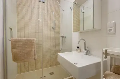 a white bathroom with a sink and a shower at Deluxe suite in prime location in Prague