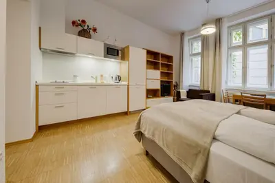 a bedroom with a large bed and a kitchen at Deluxe suite in prime location in Prague