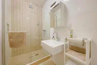 a white bathroom with a sink and a shower at Deluxe suite in prime location in Prague