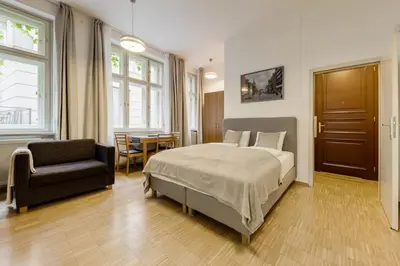 a bedroom with a bed and a chair and a table at Deluxe suite in prime location in Prague