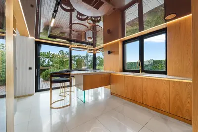 a kitchen with large windows and a counter with a stool at Chandelier Sky Mansion in Tuchoměřice