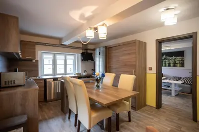 a kitchen and dining room with a wooden table and chairs at Spacious Apartment 20 Min from National Theatre in Prague