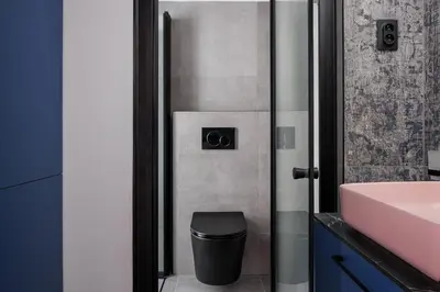 a bathroom with a trash can next to a sink at Stay2gether M&M Studio Holešovice in Prague
