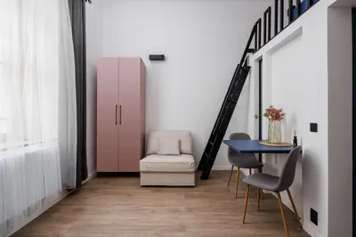 a dining room with a pink cabinet and a table at Stay2gether M&M Studio Holešovice in Prague