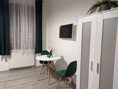 a room with a table and two chairs and a tv at Penzion Grand Nymburk in Nymburk