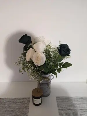 a vase filled with white roses on a table at Penzion Grand Nymburk in Nymburk