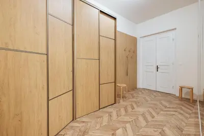 a room with wooden panels and a hallway with a chair at Prague Days - Spacious Apartment with Balcony near Wenceslas Square in Prague