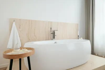 a white bath tub in a bathroom with a table at Prague Days - Spacious Apartment with Balcony near Wenceslas Square in Prague