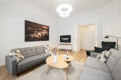 a living room with two couches and a table at Prague Days - Spacious Apartment with Balcony near Wenceslas Square in Prague