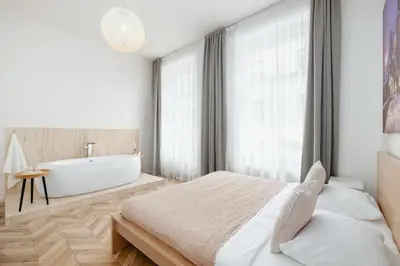 a bedroom with a tub and a bed and a bath room at Prague Days - Spacious Apartment with Balcony near Wenceslas Square in Prague