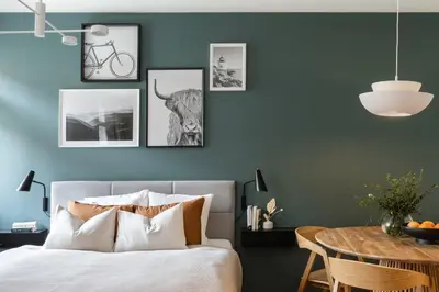a bedroom with a green wall with a bed and a table at Prague Days - Deluxe Two-bedroom Apartment in New Town in Prague