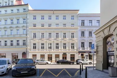 a large white building with cars parked in front of it at Prague Days - Deluxe Two-bedroom Apartment in New Town in Prague