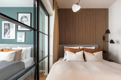 a bedroom with two beds and a large window at Prague Days - Deluxe Two-bedroom Apartment in New Town in Prague