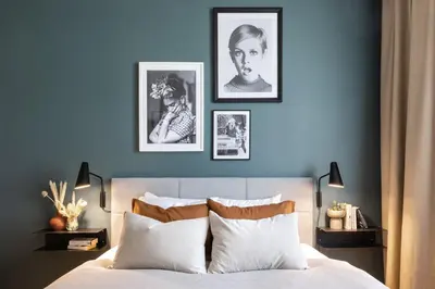 a bedroom with a blue wall with pictures above a bed at Prague Days - Deluxe Two-bedroom Apartment in New Town in Prague