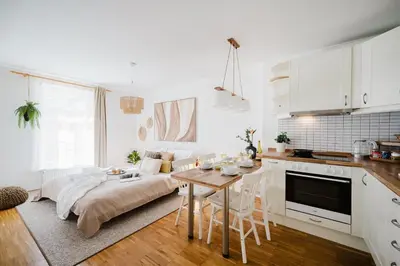 a kitchen and living room with a table and a couch at Prague Days - Studio with Workspace by TV Tower in Žižkov in Prague
