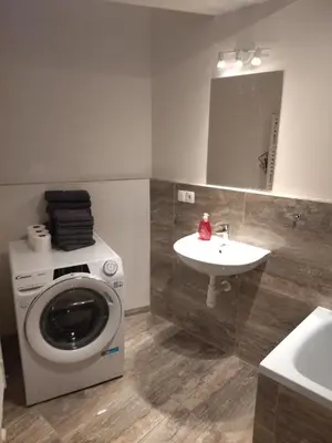 a bathroom with a washing machine and a sink at Brand new studio apartment #24 in Elite residence with free secure parking in the center in Prague