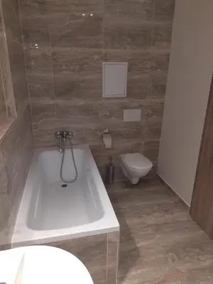 a bathroom with a white tub and a toilet at Brand new studio apartment #24 in Elite residence with free secure parking in the center in Prague