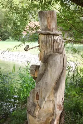 a wooden statue of a person wearing a hat at Apartmán Ve Mlýně in Třebotov