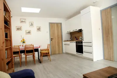 a kitchen and dining room with a table and chairs at Apartmán Ve Mlýně in Třebotov