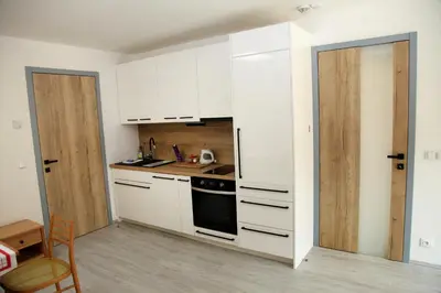 a kitchen with white cabinets and a stove at Apartmán Ve Mlýně in Třebotov