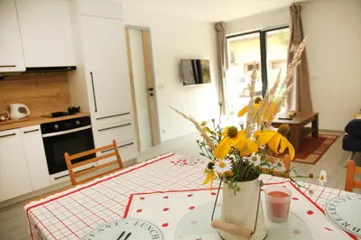 a kitchen with a table with a vase of flowers at Apartmán Ve Mlýně in Třebotov