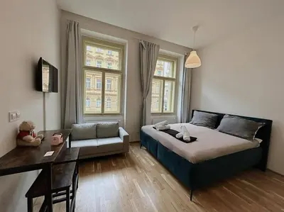 a bedroom with a bed and a table and a couch at Apt near Muzeum Prague 1 in Prague