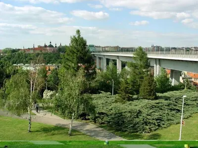a bridge over a park with trees and a building at Apt near Muzeum Prague 1 in Prague