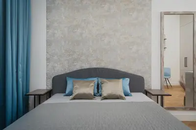a bedroom with a large bed with blue pillows at Palace Dlazdena – Stylish Prague Centre Apartment in Prague