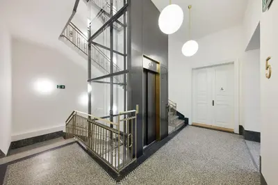 a hallway with stairs and a door in a building at Palace Dlazdena – Stylish Prague Centre Apartment in Prague